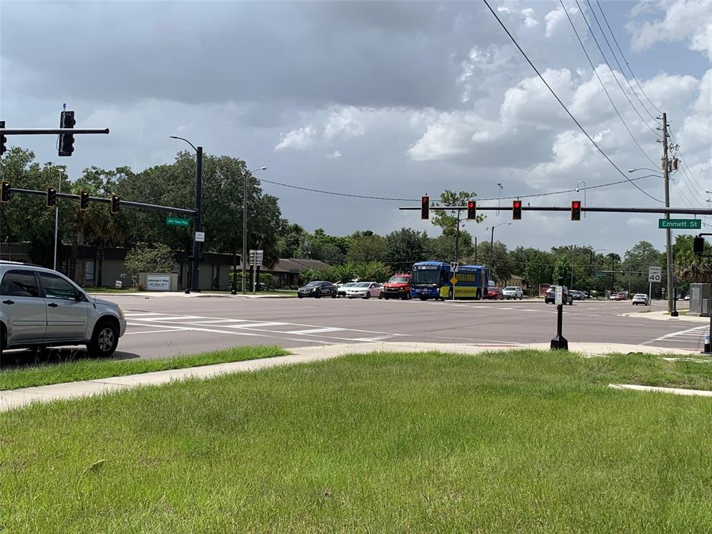 A view of a street intersection with traffic lights, a bus, and cars under a cloudy sky — 3 S JOHN YOUNG PARKWAY UNIT 4, KISSIMMEE, FL