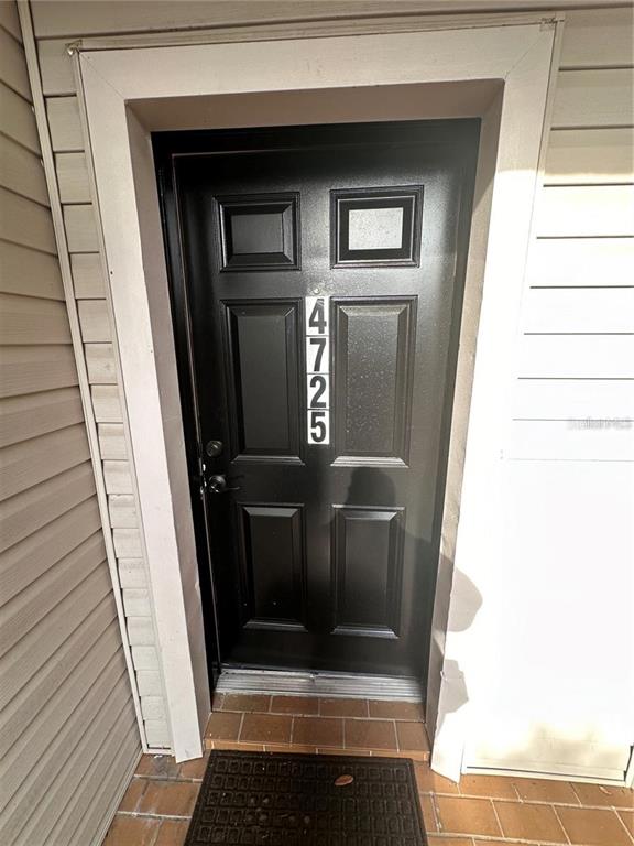 A black front door with the number 4725 is set within a white-trimmed entryway — 4725 PURITAN CIRCLE UNIT 603, TAMPA, FL