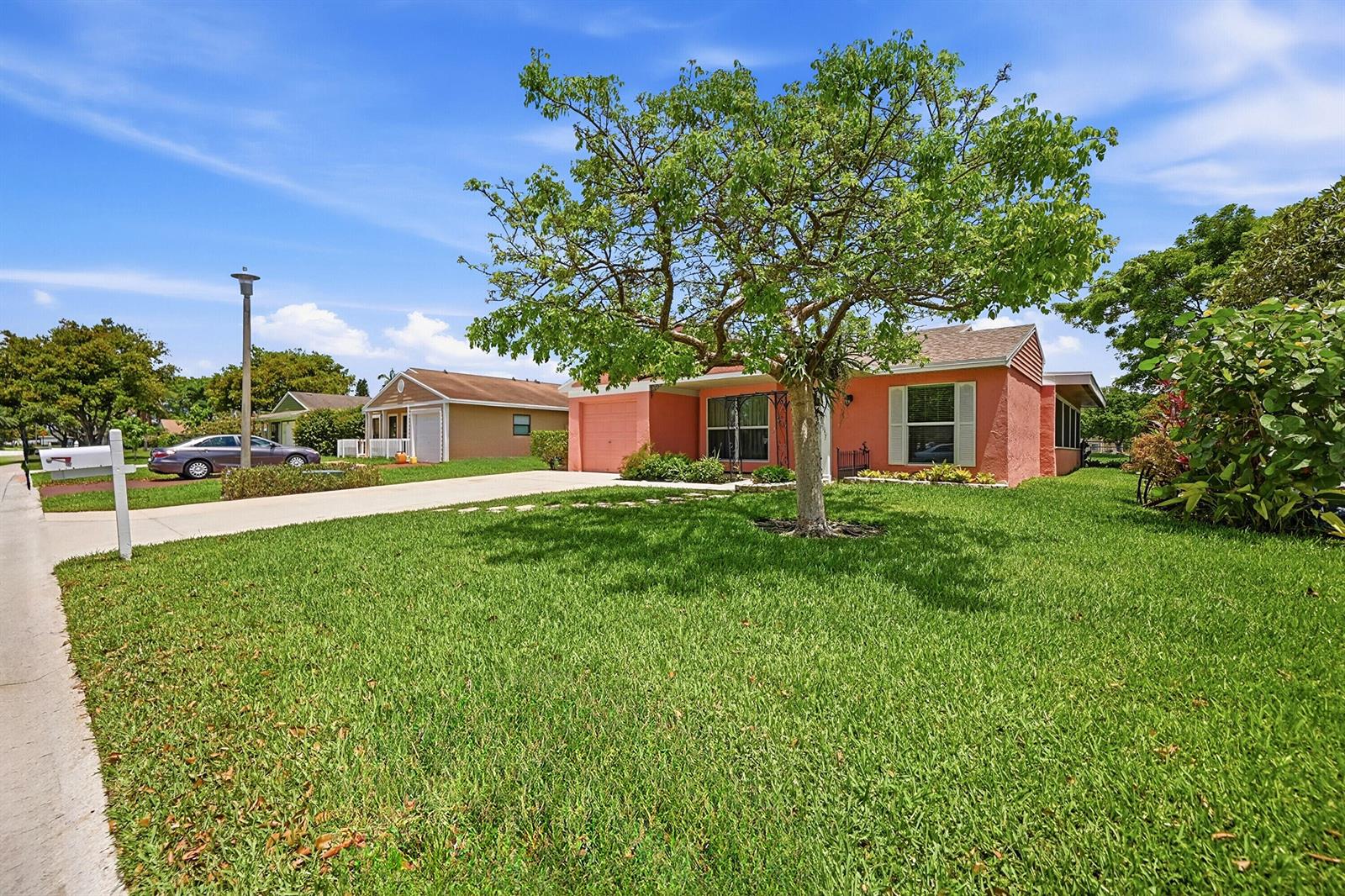 A single-story peach-colored house with a large front yard and a prominent tree — 8131 Countrypark Drive, Boca Raton FL 33433, BOCA RATON, FL