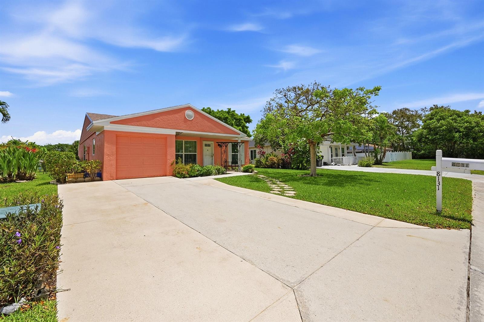 A single-story peach-colored house with a concrete driveway and a green front lawn — 8131 Countrypark Drive, Boca Raton FL 33433, BOCA RATON, FL