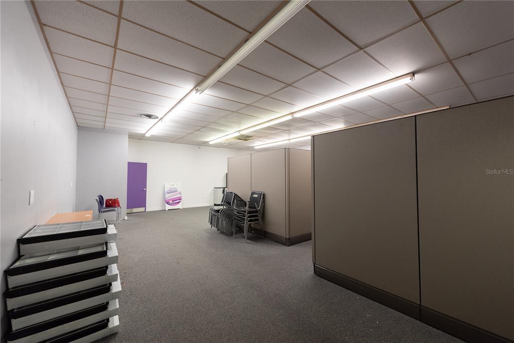 An office space features gray carpet, drop ceilings with fluorescent lights, and modular partition walls — 5118 US HWY 19, NEW PORT RICHEY, FL