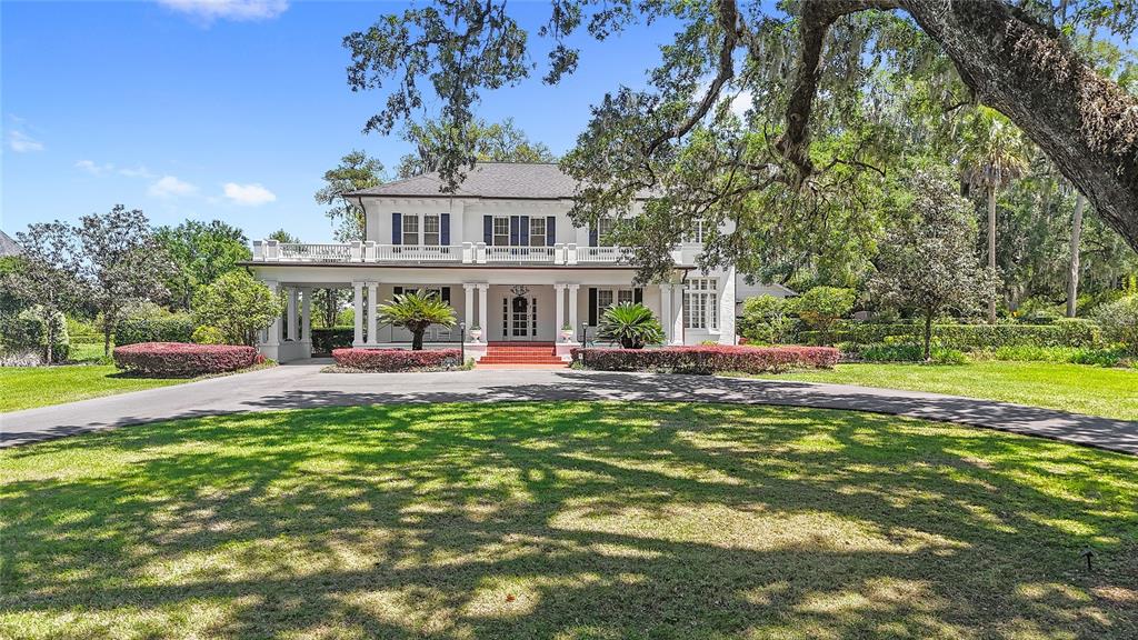 A two-story white house with a large front porch and a circular driveway — 405 SE 15TH AVENUE, OCALA, FL