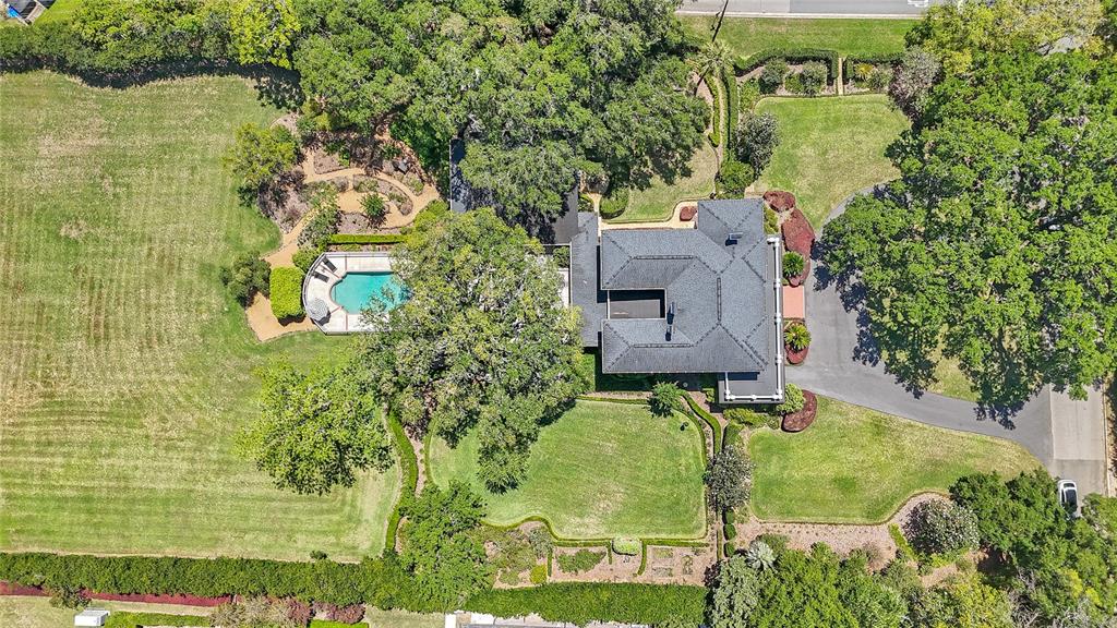 An aerial view shows a house with a dark roof, a pool, and extensive landscaping — 405 SE 15TH AVENUE, OCALA, FL