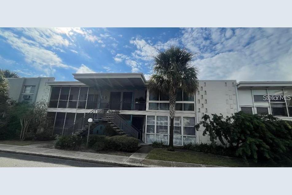 A two-story apartment building with a central staircase and a palm tree in front — 151 N ORLANDO AVENUE UNIT 118, WINTER PARK, FL