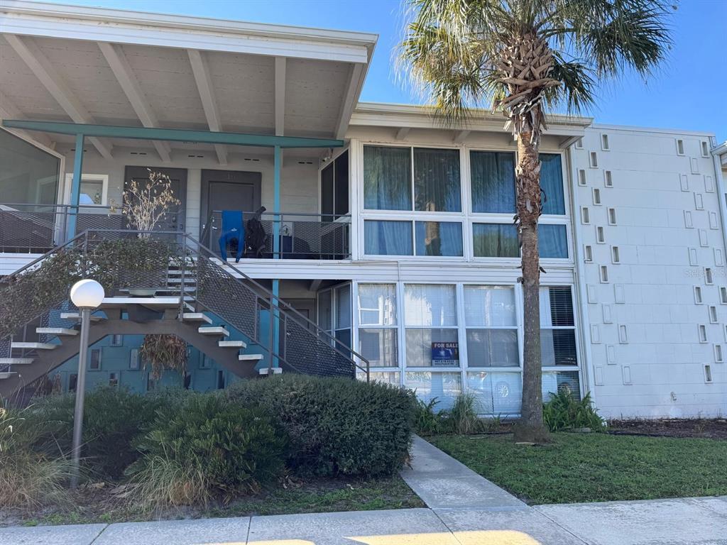 A two-story apartment building with a metal staircase, a palm tree, and large windows — 151 N ORLANDO AVENUE UNIT 118, WINTER PARK, FL