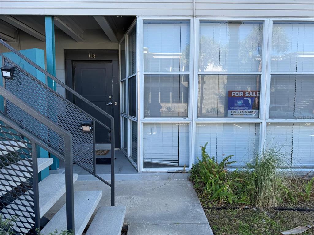 A dark gray front door with the number 118 above it sits on a porch — 151 N ORLANDO AVENUE UNIT 118, WINTER PARK, FL