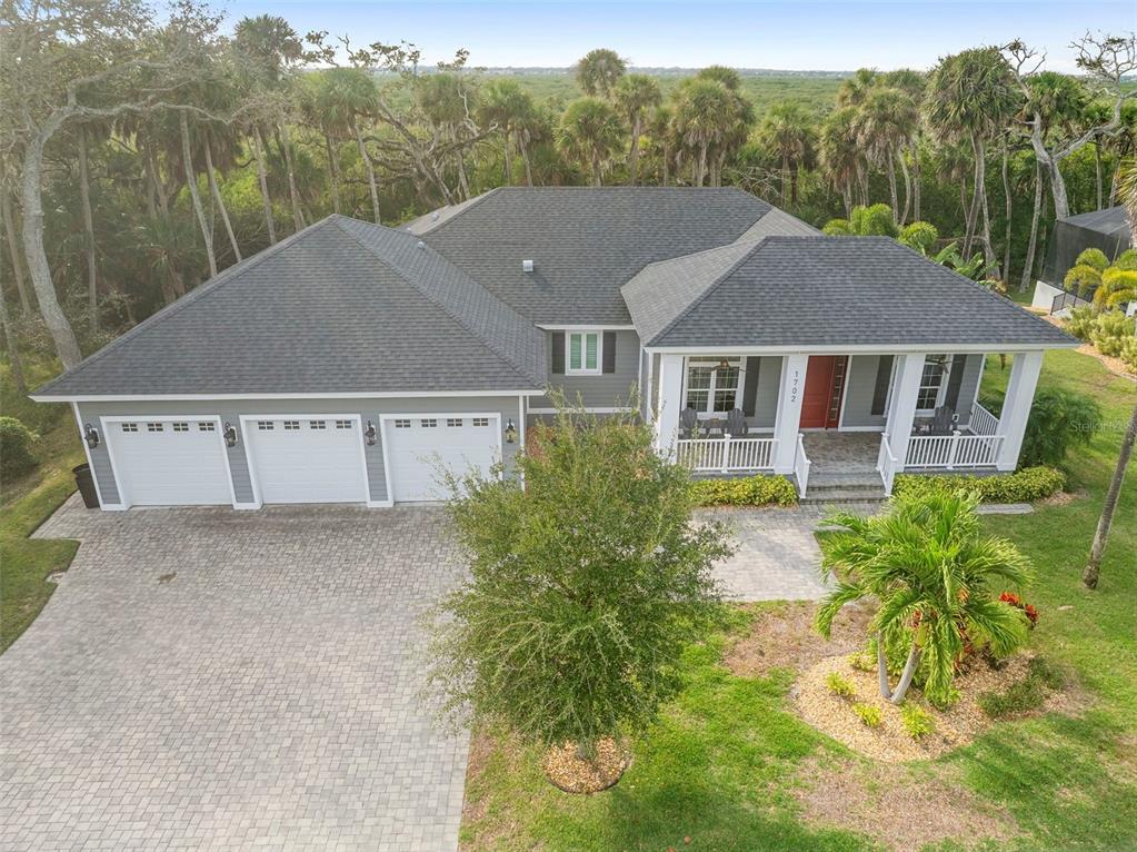 An aerial view of a gray single-story house with a three-car garage and porch — 1702 SAXON DRIVE, NEW SMYRNA BEACH, FL