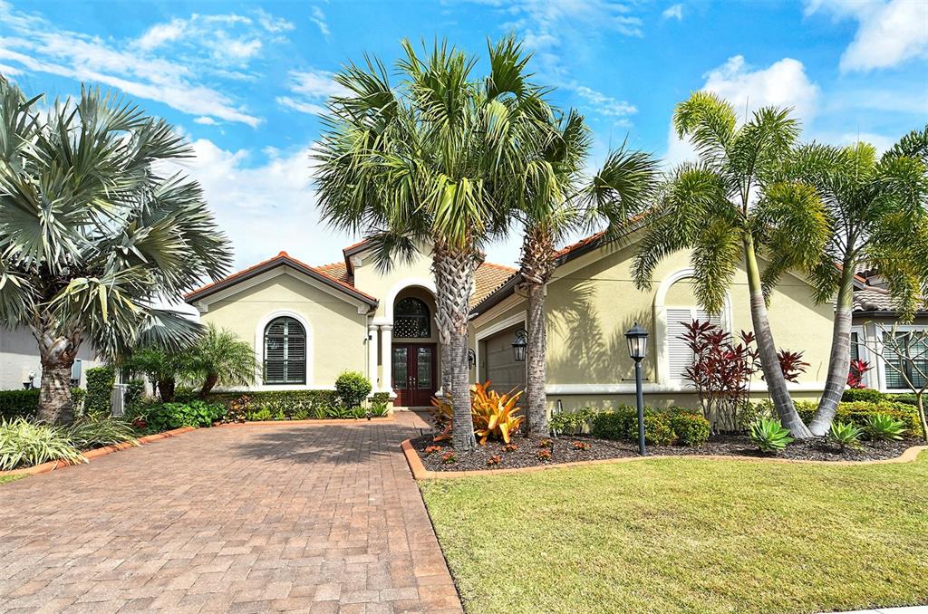 A single-story house with a paved driveway, palm trees, and a tiled roof — 4735 CABREO COURT, LAKEWOOD RANCH, FL