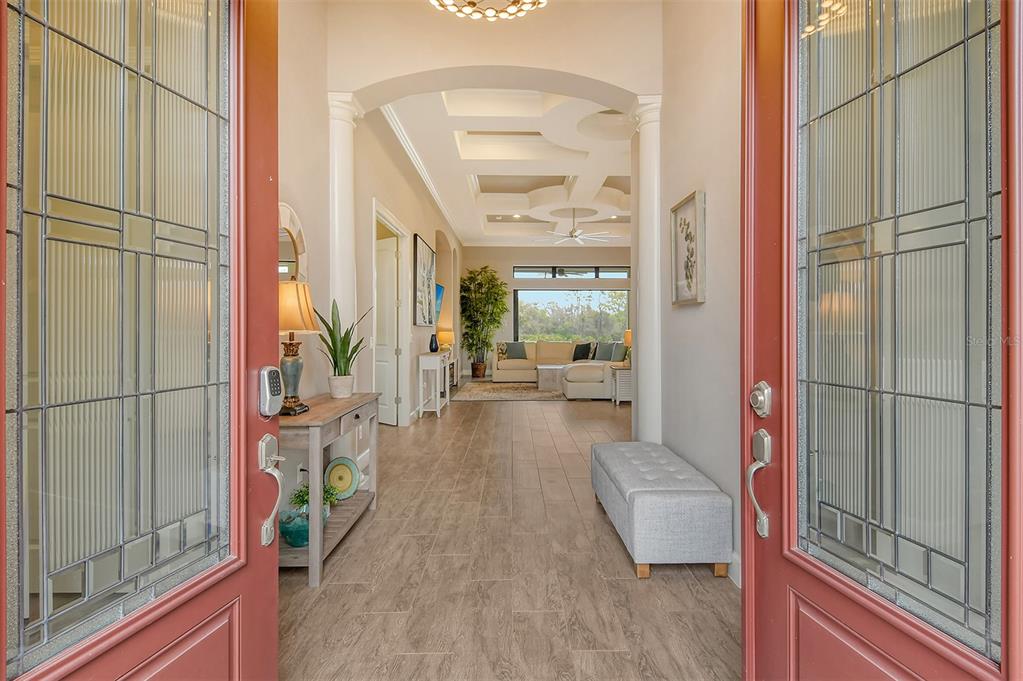 A view through an open front door into a tiled foyer leading to a living room — 4735 CABREO COURT, LAKEWOOD RANCH, FL