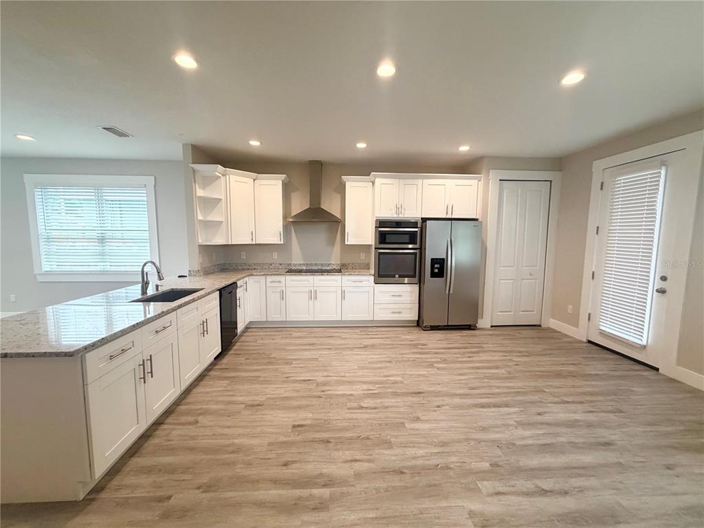 A kitchen with white cabinets, stainless steel appliances, and a granite-topped island — 2125 W SAINT JOSEPH STREET, TAMPA, FL