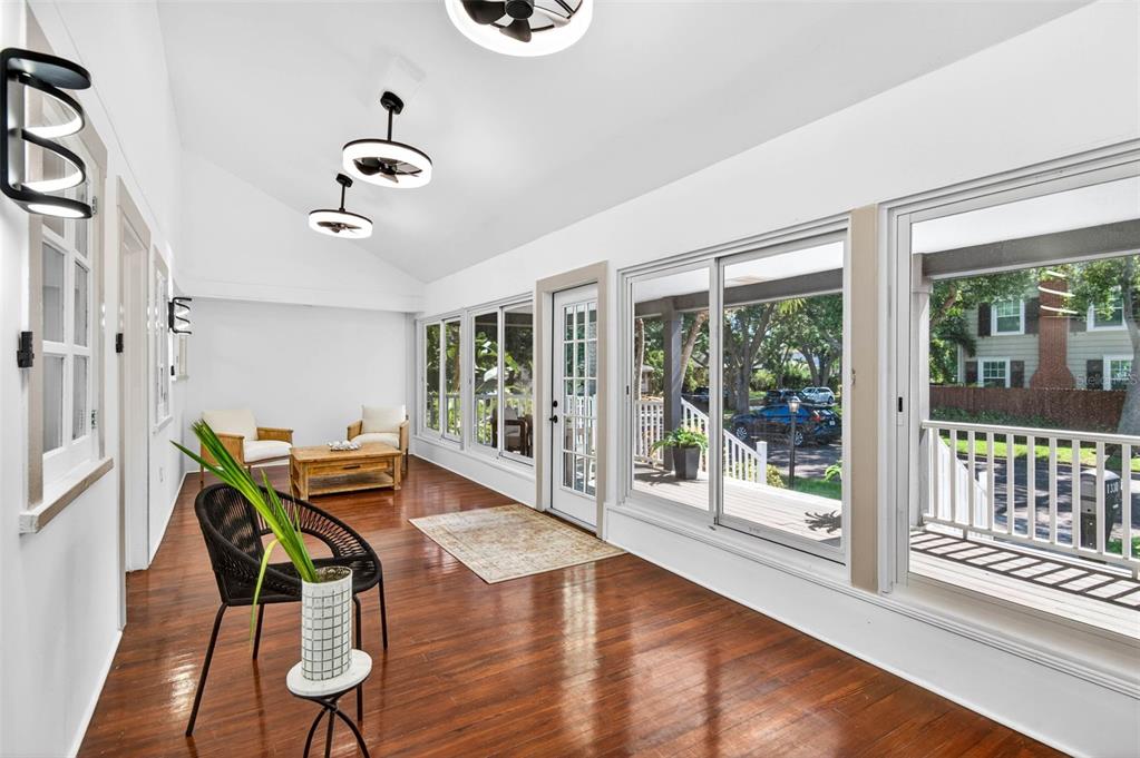 A sunroom with hardwood floors, large sliding glass doors, and a modern ceiling fan — 1330 CHERRY STREET NE, ST PETERSBURG, FL