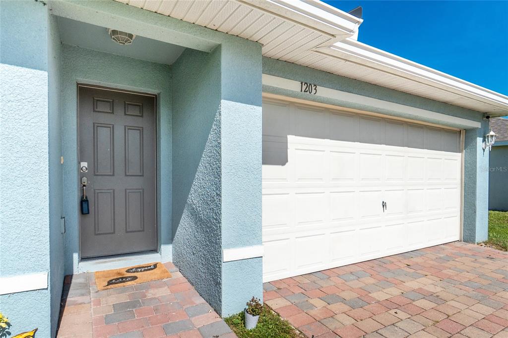 The exterior view shows a light blue house with a gray front door and garage — 1203 DESMOND STREET, PORT CHARLOTTE, FL
