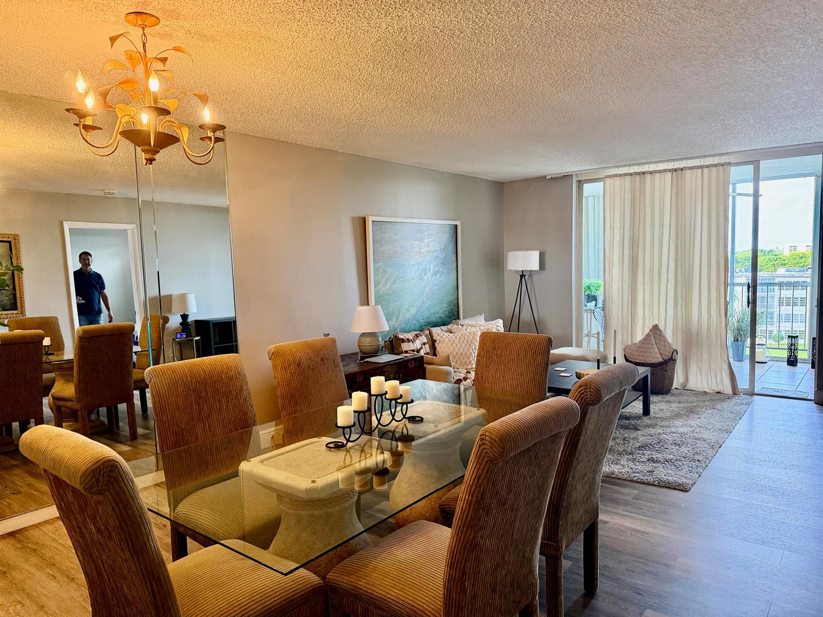 A dining area with a glass table and upholstered chairs opens into a living room — 14671 Bonaire Boulevard # 604, Delray Beach FL 33446, DELRAY BEACH, FL
