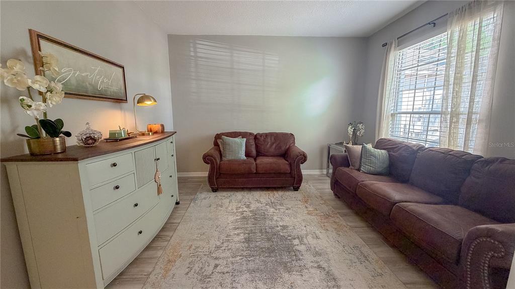 A living room features a light-colored dresser, a brown loveseat, and a brown sofa — 310 SUNSET VIEW DRIVE, DAVENPORT, FL
