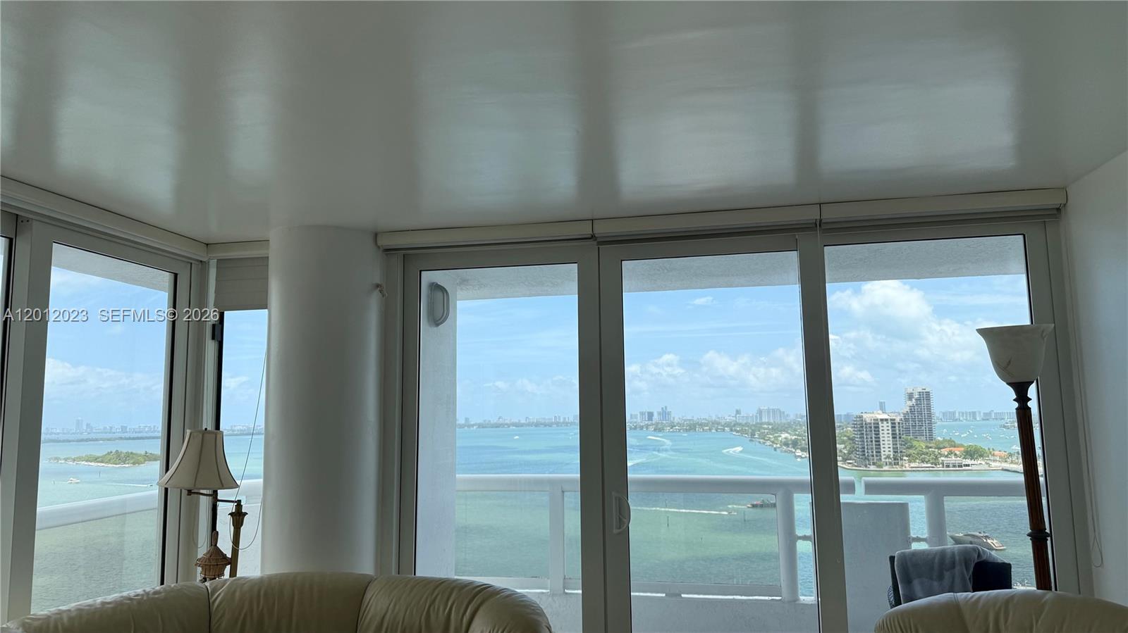 A living room with floor-to-ceiling windows offers a panoramic view of the bay and city — 1717 N Bayshore Dr # 1734, Miami FL 33132, MIAMI, FL