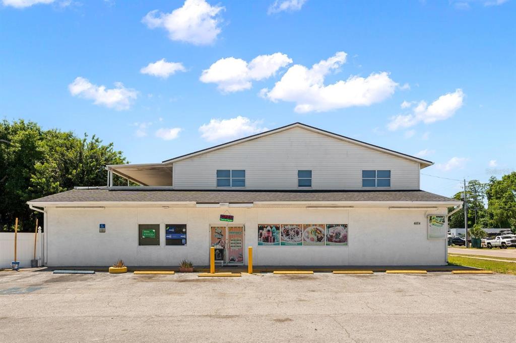 A single-story commercial building with a white facade, a parking lot, and a gabled roof — 4624 N HUBERT AVENUE, TAMPA, FL