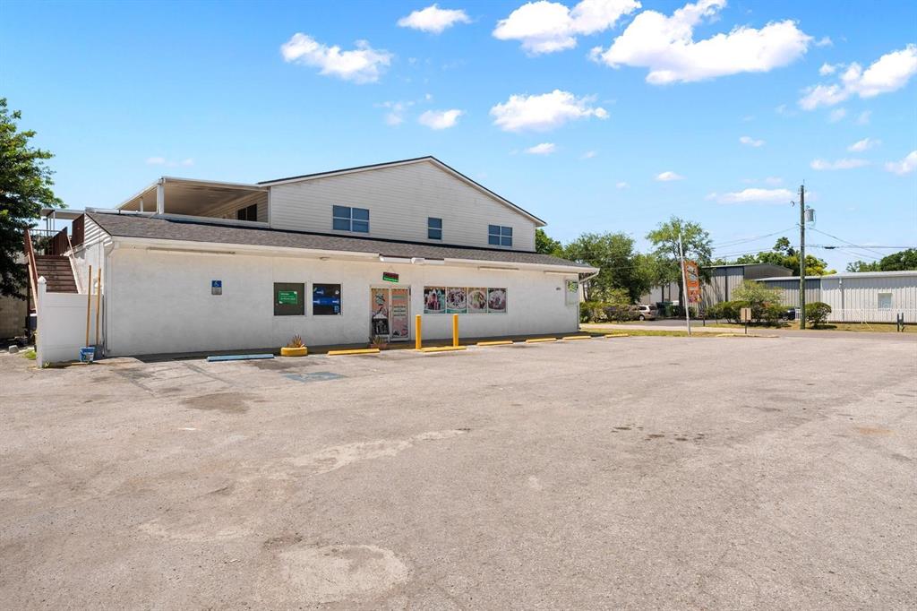 A two-story commercial building with a white exterior and a large asphalt parking lot — 4624 N HUBERT AVENUE, TAMPA, FL