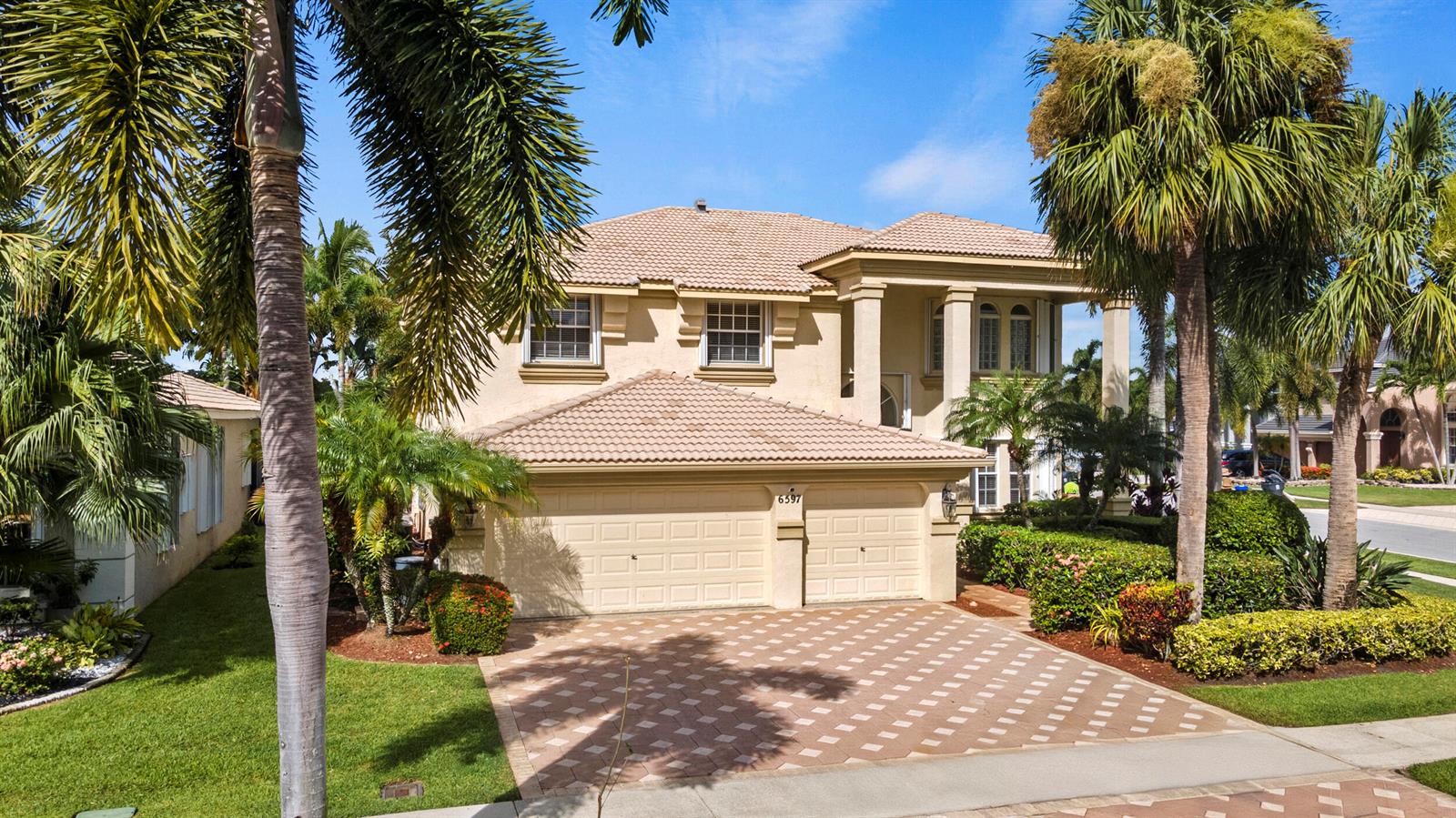 A two-story beige house with a tiled roof, a two-car garage, and palm trees — 6597 Marbletree Lane, Lake Worth FL 33467, LAKE WORTH, FL