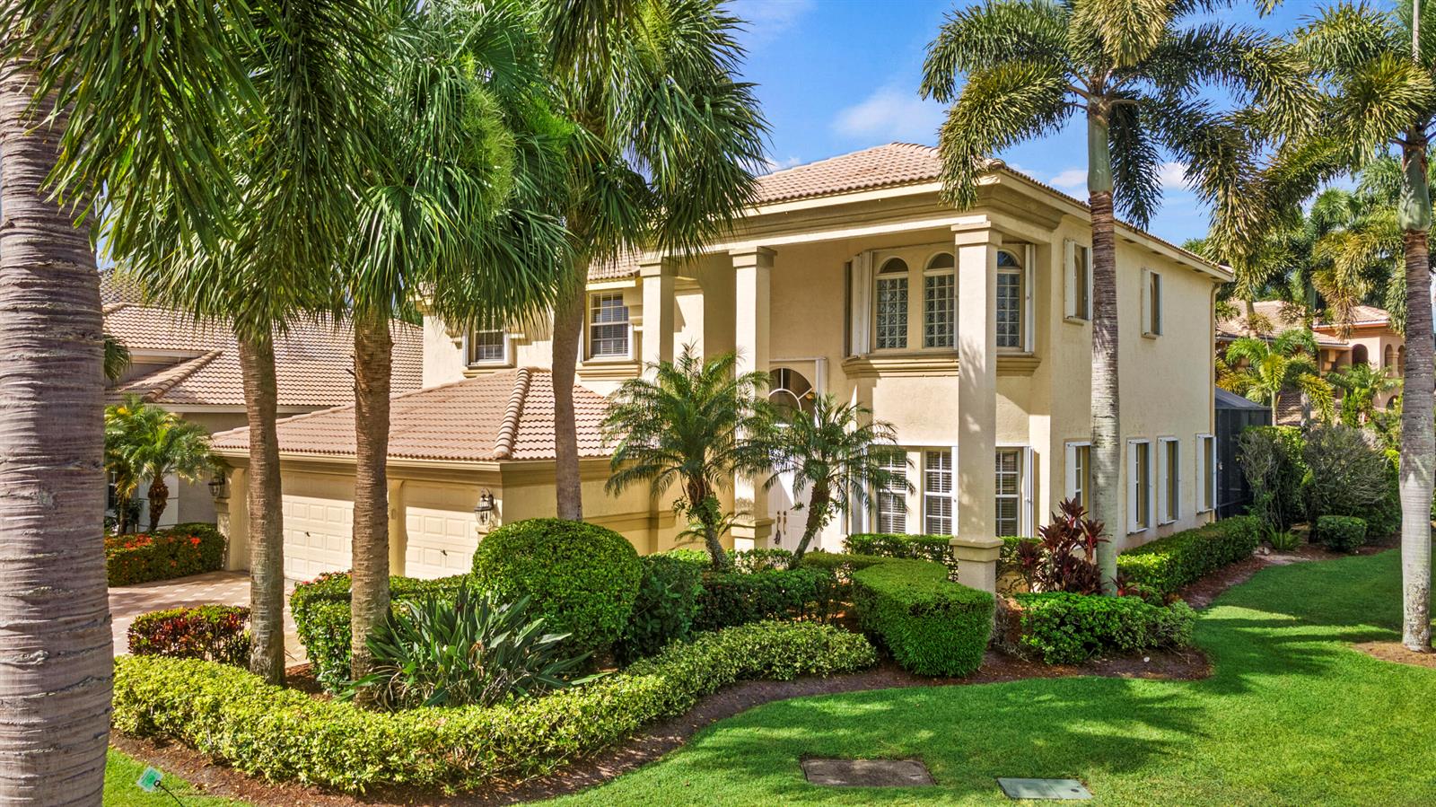 A two-story stucco house with a tile roof, palm trees, and manicured landscaping — 6597 Marbletree Lane, Lake Worth FL 33467, LAKE WORTH, FL