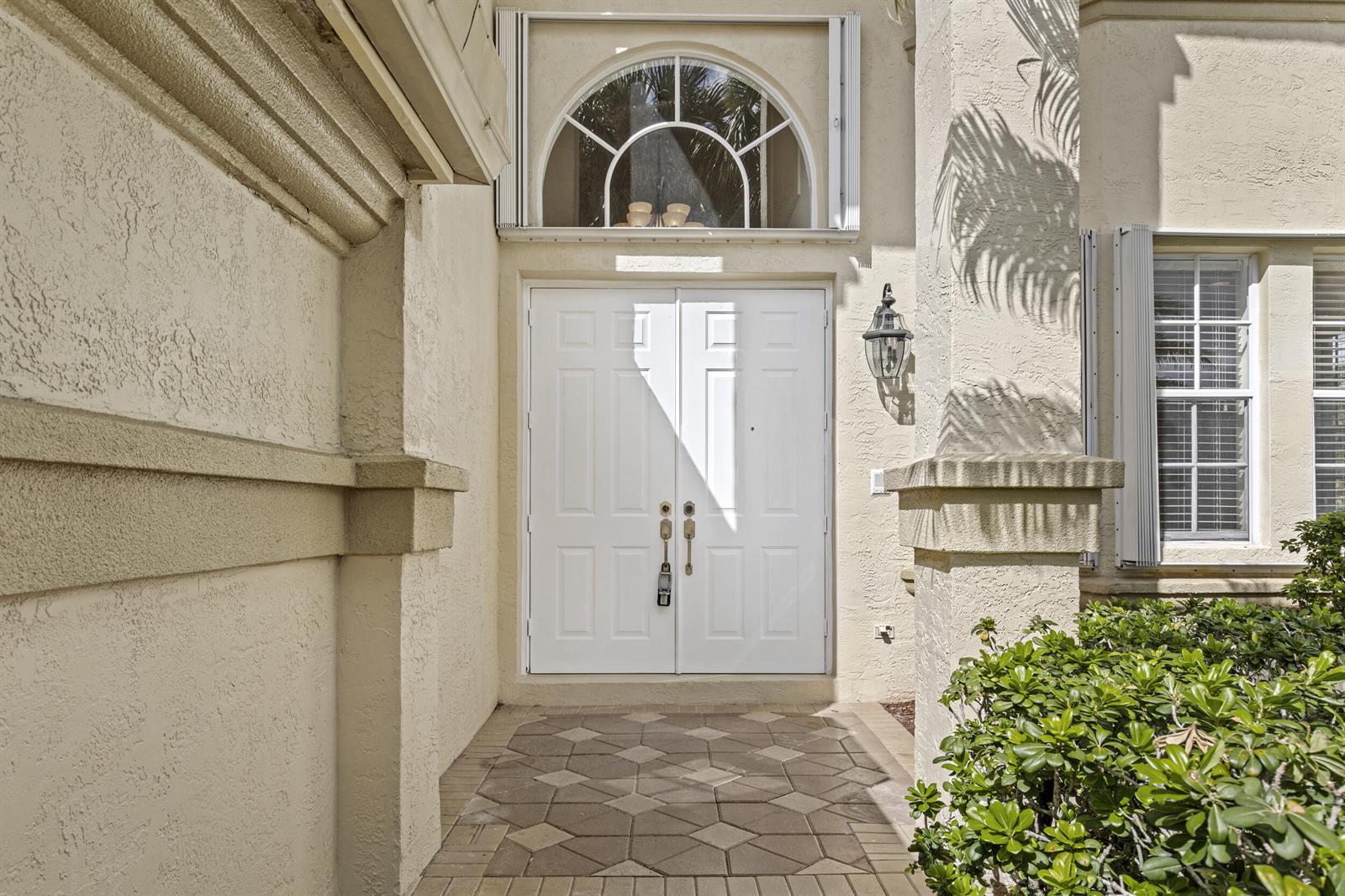 A white double front door with a transom window and a paved entryway — 6597 Marbletree Lane, Lake Worth FL 33467, LAKE WORTH, FL