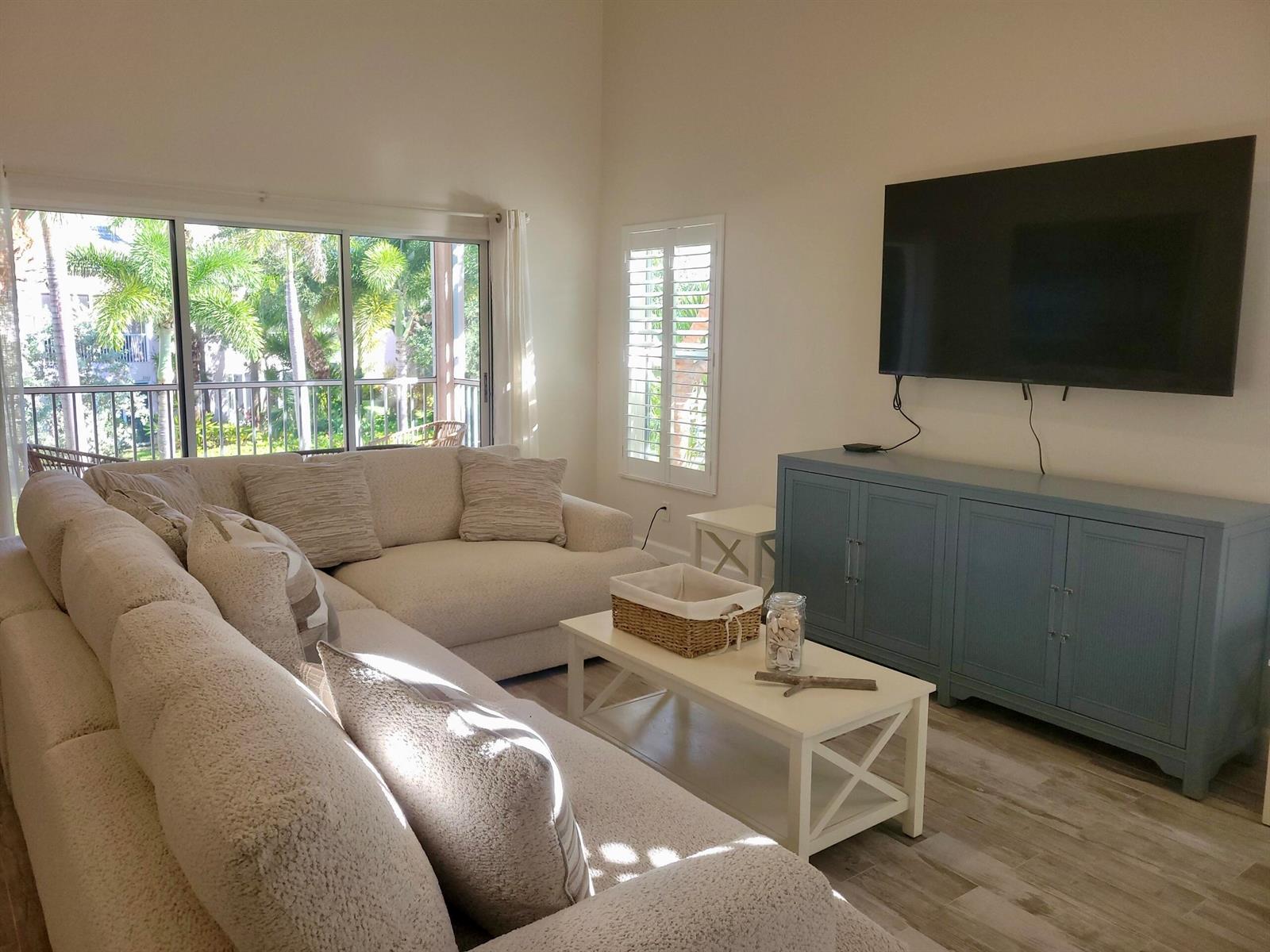 A living room features a large sectional sofa, a white coffee table, and a blue console — 3108 Fairway Drive N, Jupiter FL 33477, JUPITER, FL