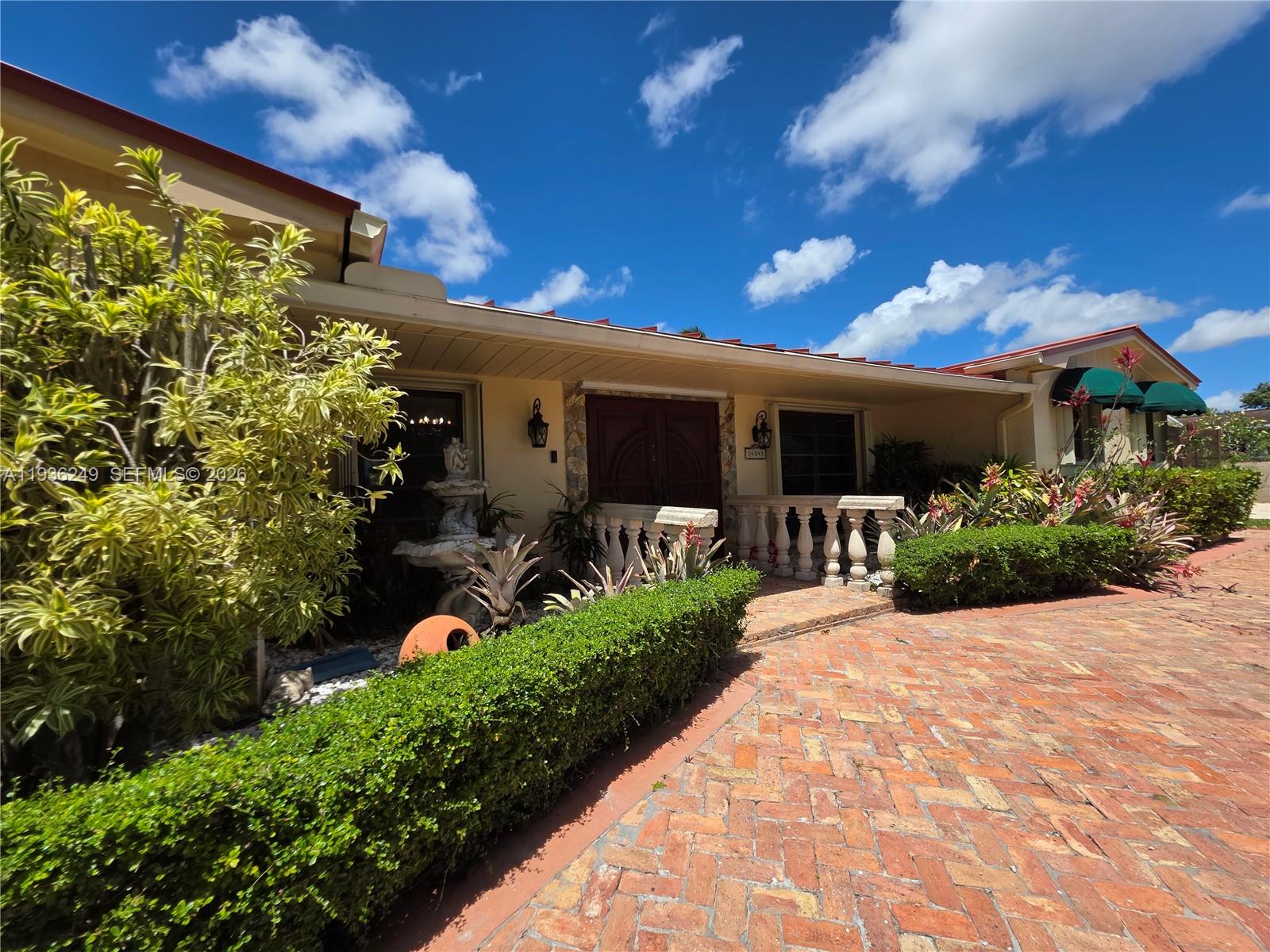 A brick driveway leads to the entrance of a house with a stone balustrade — 14545 SW 75th St, Miami FL 33183, MIAMI, FL