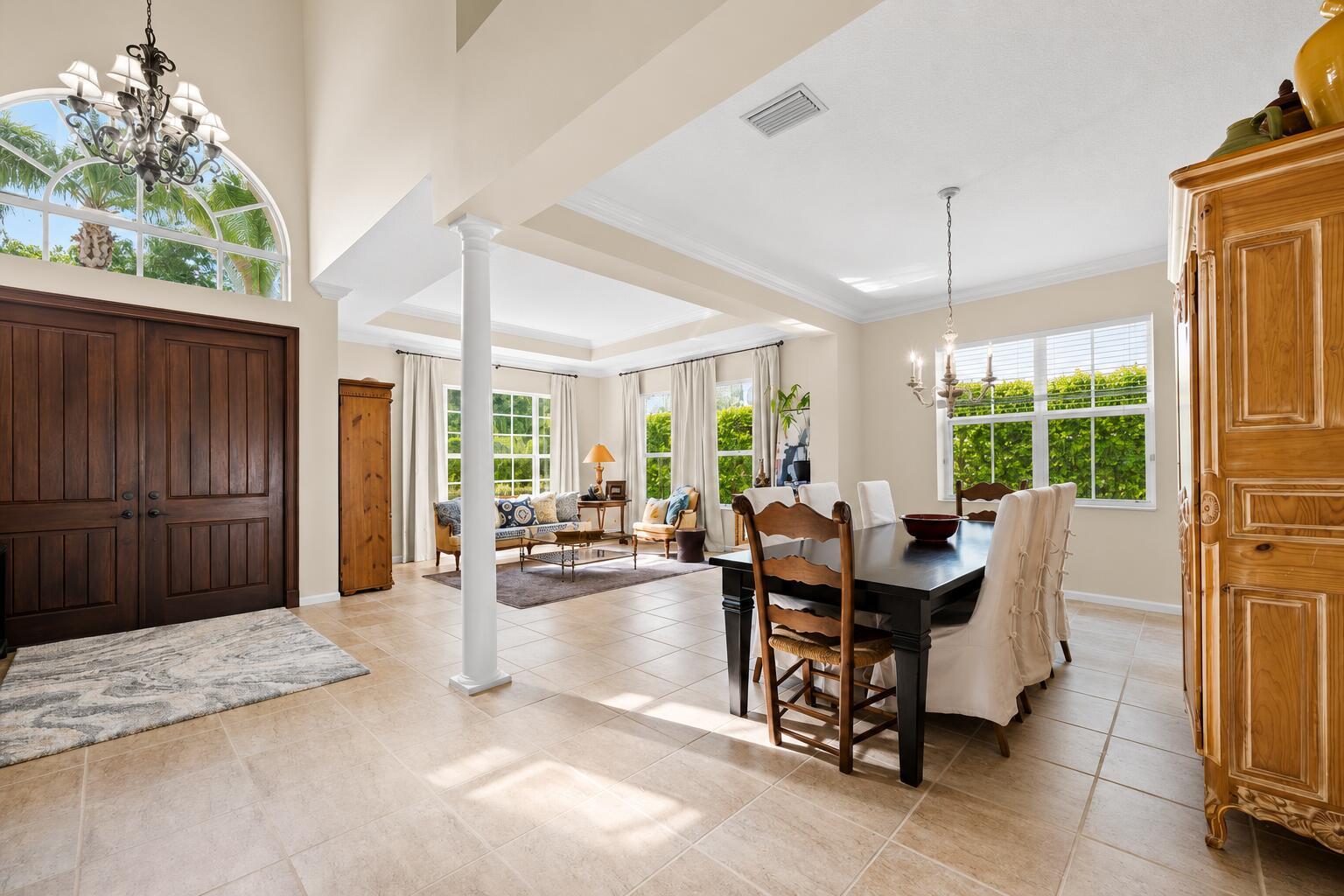 A dining area and living room with tile floors, high ceilings, and large windows — 464 Oriole Lane, Jupiter FL 33458, JUPITER, FL