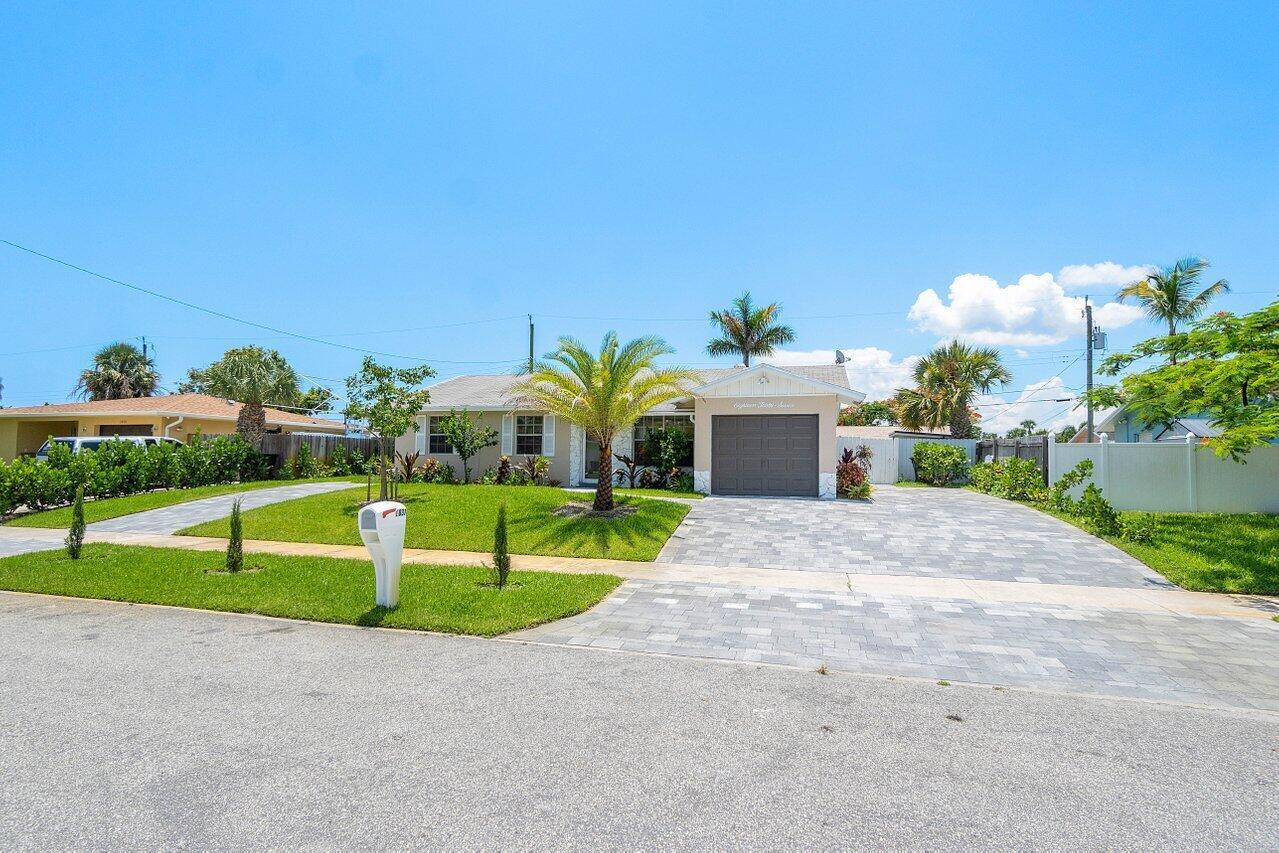 A single-story house with a paved driveway, a front lawn, and a garage — 1837 16th Avenue N, FL 33460, FL