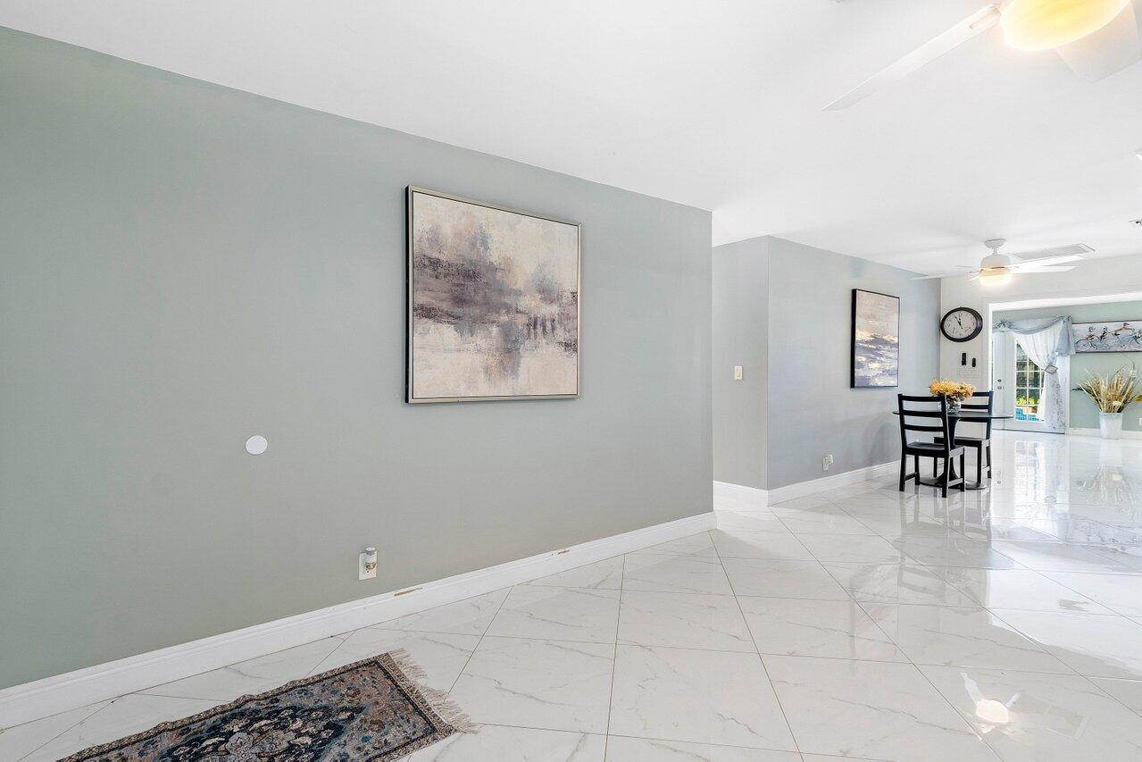 A dining area with a table and chairs is visible from a tiled hallway — 1837 16th Avenue N, FL 33460, FL