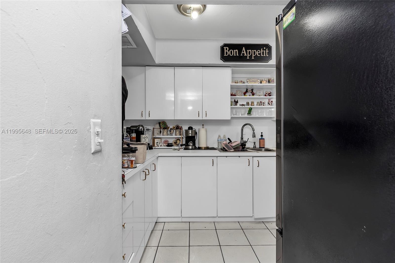 A kitchen features white cabinets, a stainless steel sink, a gas stove, and tiled flooring — 805 W 79th Pl, Hialeah FL 33014, HIALEAH, FL