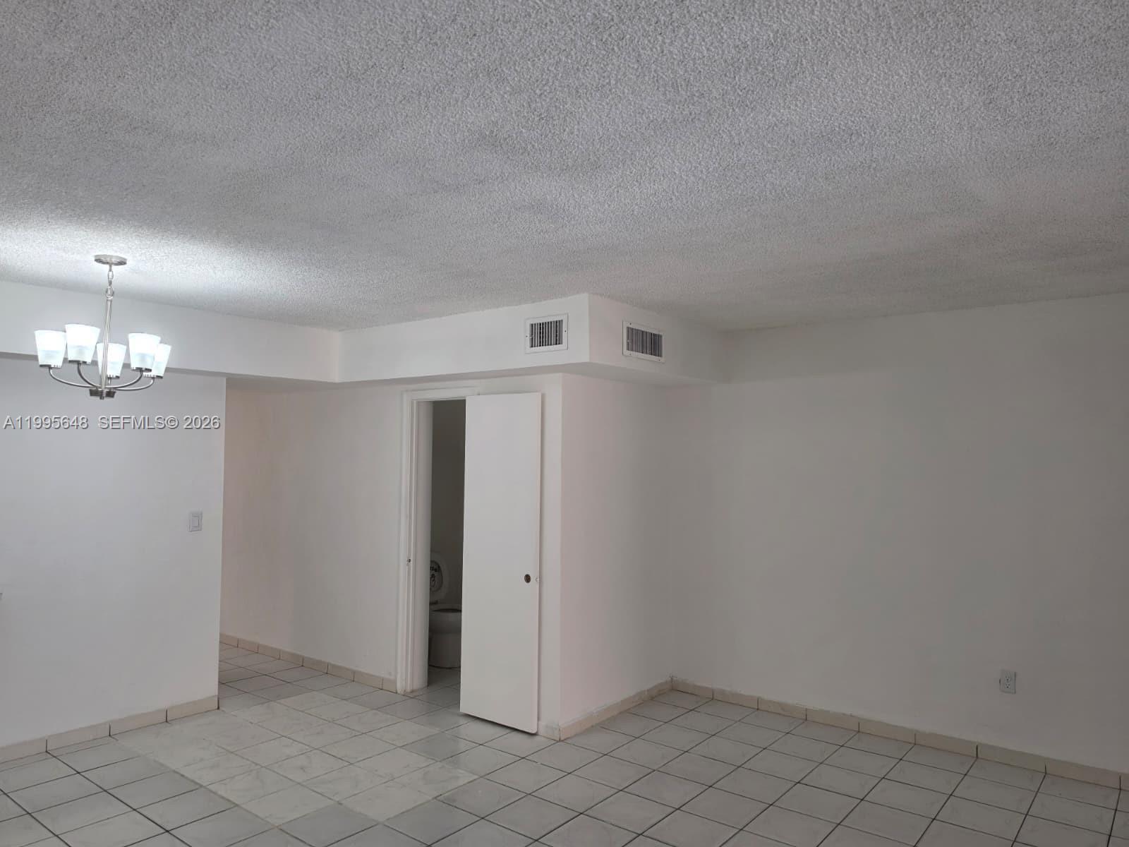A staircase with tiled steps leads upward toward a ceiling light fixture and thermostat — 805 W 79th Pl, Hialeah FL 33014, HIALEAH, FL