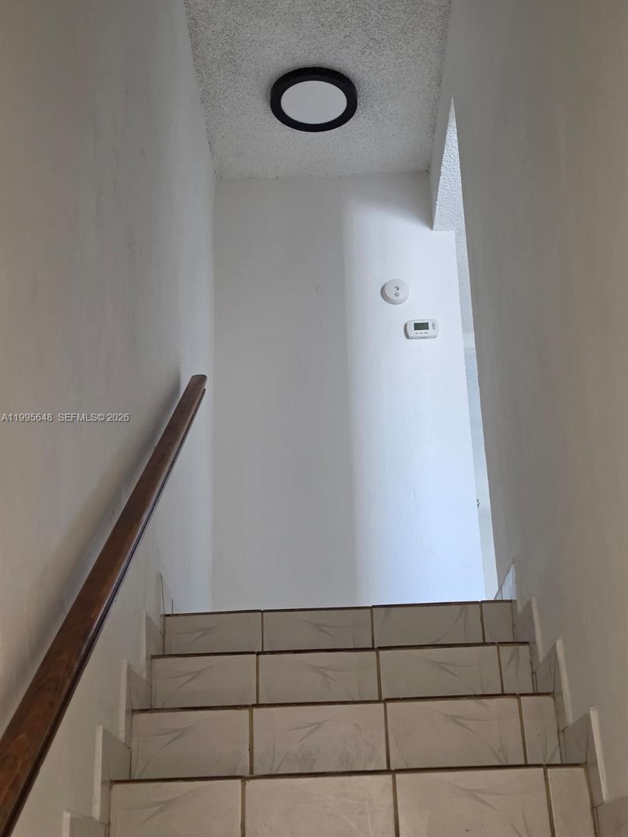A bathroom vanity features a white cabinet, a white countertop, and a black faucet — 805 W 79th Pl, Hialeah FL 33014, HIALEAH, FL