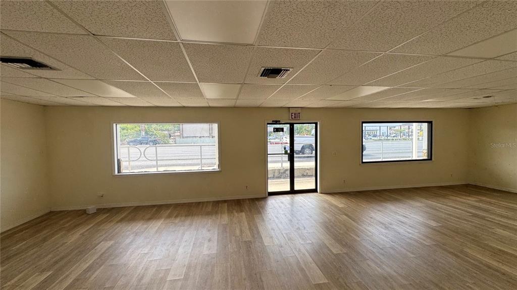 An empty commercial space features light wood-look flooring, a drop ceiling, and two windows — 4065 S SUNCOAST BOULEVARD, HOMOSASSA, FL