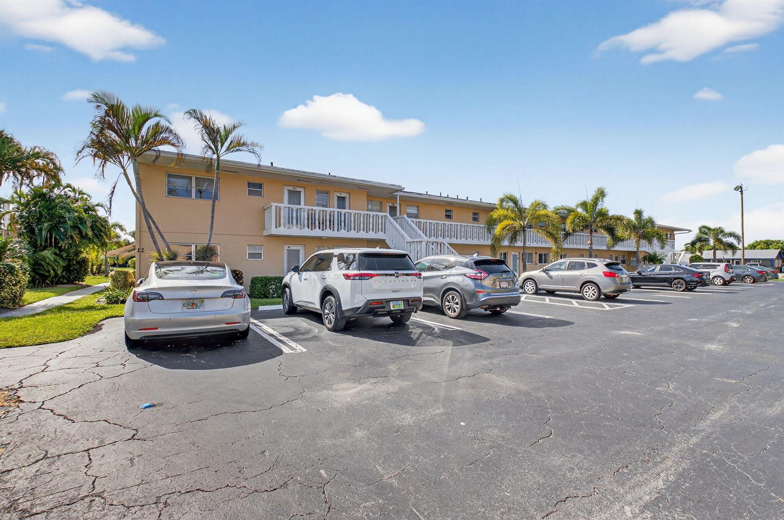 A two-story apartment building with a parking lot in front and several parked cars — 2152 NE 1st Way # 101, Boynton Beach FL 33435, BOYNTON BEACH, FL
