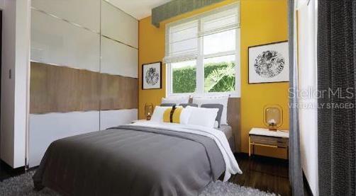 This virtually staged bedroom features a grey bed, yellow accent wall, and large sliding closet doors — L10 CARR. 14 BO CERRILLOS, PONCE, PR