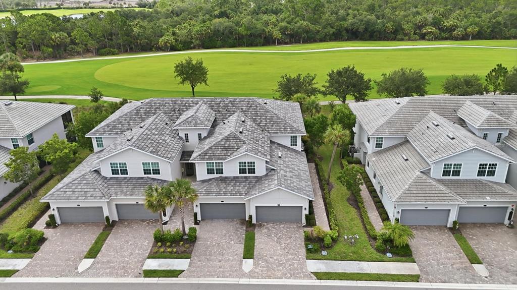 An aerial view of two multi-unit residential buildings with gray roofs and paved driveways — 14648 SYCAMORE COURT UNIT 3012, PUNTA GORDA, FL