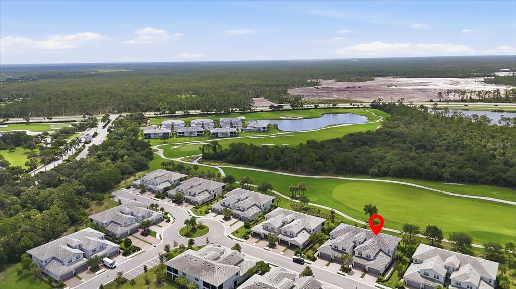 An aerial view shows a residential community with townhouses situated next to a golf course — 14648 SYCAMORE COURT UNIT 3012, PUNTA GORDA, FL