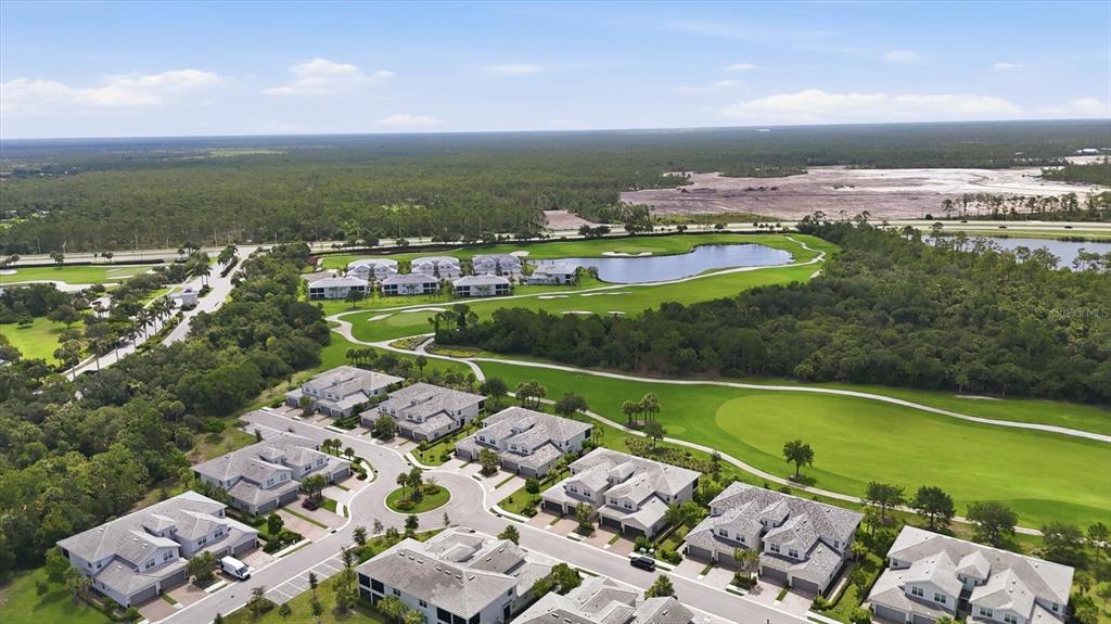 An aerial view shows a residential community with townhomes situated alongside a golf course — 14648 SYCAMORE COURT UNIT 3012, PUNTA GORDA, FL