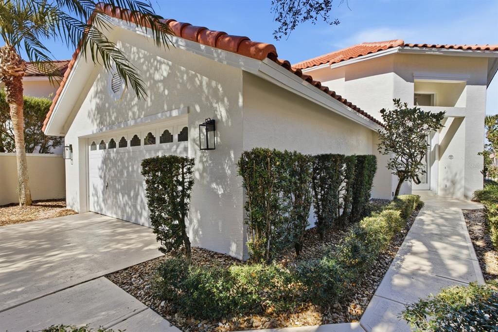 A white house exterior features a garage, a tiled roof, and a landscaped walkway — 13 MADEIRA COURT, PALM COAST, FL