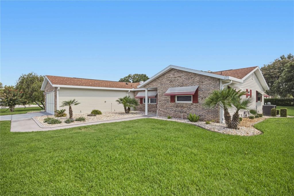 A single-story house with a brick facade, light siding, and a garage on a lawn — 17676 SE 102ND CIRCLE, SUMMERFIELD, FL