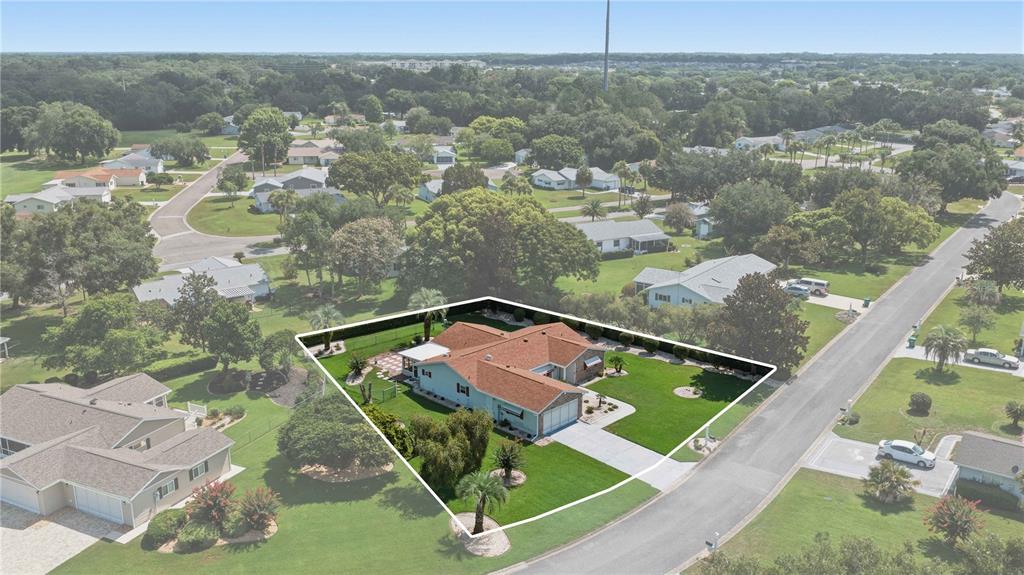 An aerial view shows a single-story house with a red roof and a large lawn — 17676 SE 102ND CIRCLE, SUMMERFIELD, FL