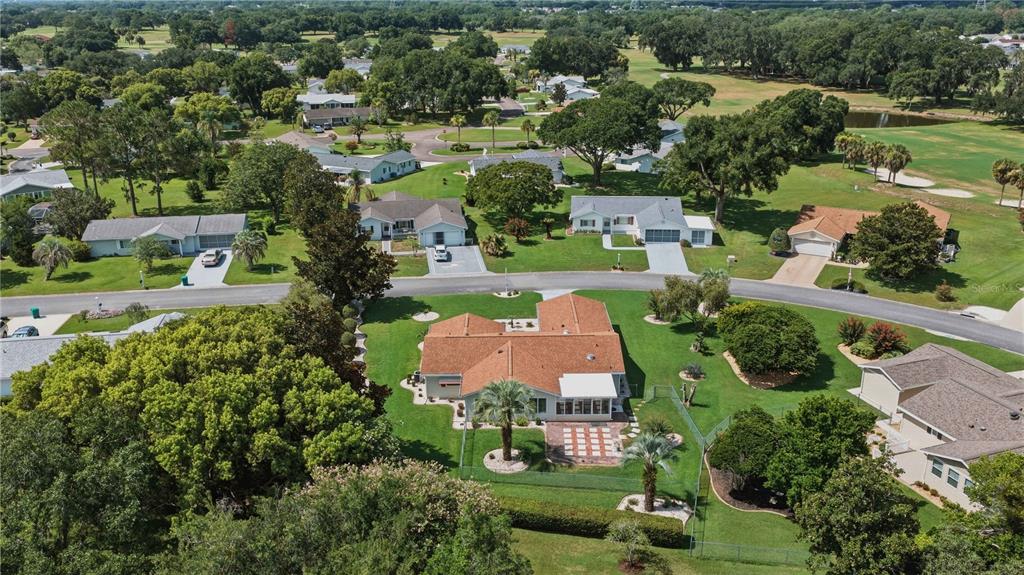 An aerial view shows a suburban house with a brown roof and a fenced backyard — 17676 SE 102ND CIRCLE, SUMMERFIELD, FL
