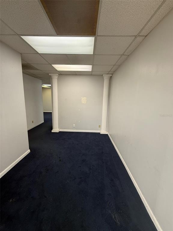 An interior office space features blue carpeting, white walls, and two decorative white columns — 5950 SW 1ST LANE, OCALA, FL