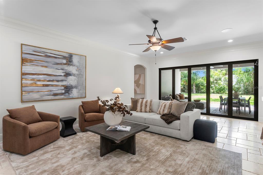 A living room features a sofa, two armchairs, a coffee table, and large sliding glass doors — 3006 S EMERSON STREET, TAMPA, FL