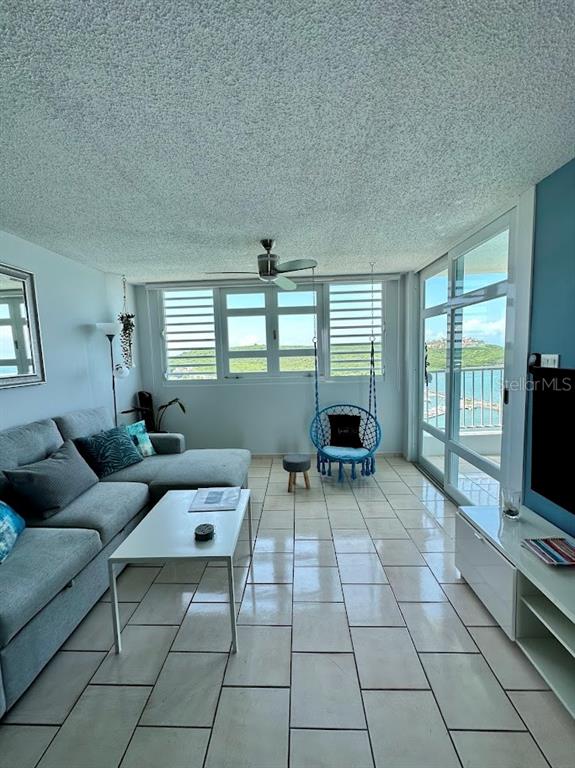 A living room with a gray sectional sofa, a hanging chair, and a balcony view — 200 MARINA VIEW DOS MARINAS II CONDOMINIUM UNIT 2103, FAJARDO, PR