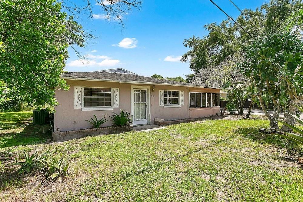A single-story house with a light-colored stucco exterior, a front porch, and a grassy yard — 2110 JAMES DRIVE, OVIEDO, FL