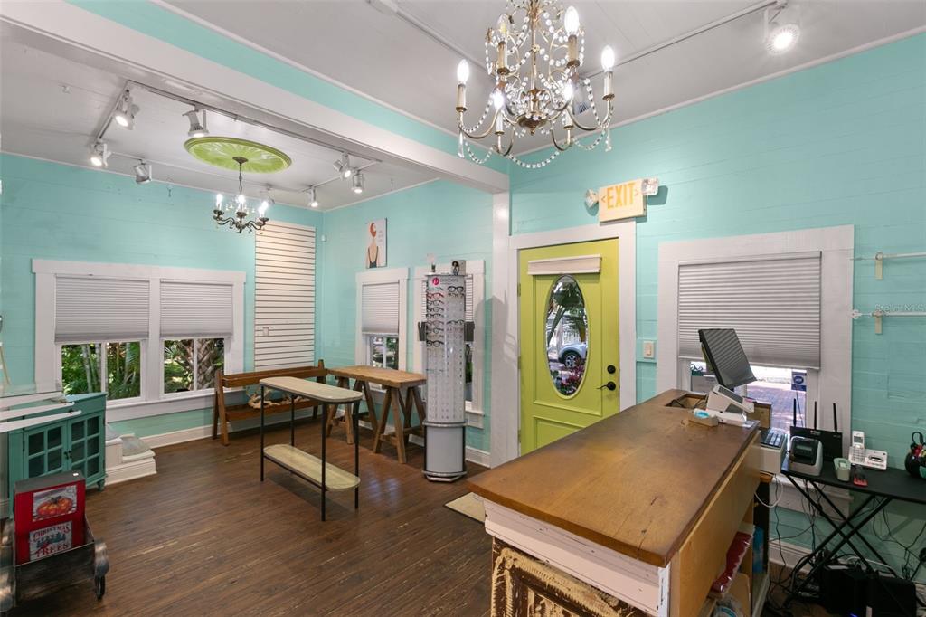 A retail space with light blue walls, wood floors, a chandelier, and a checkout counter — 135 4TH AVENUE N, SAFETY HARBOR, FL