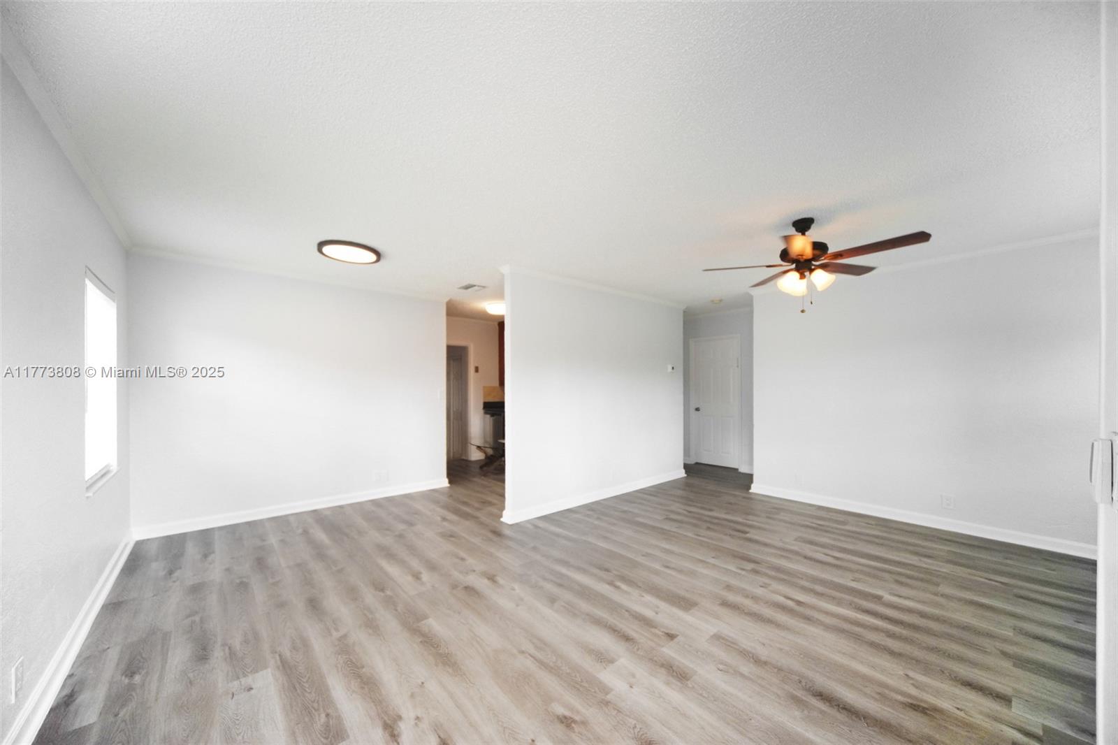 An empty room features light gray wood-look flooring, white walls, and a ceiling fan — 621 Hudson Rd, West Palm Beach FL 33405, WEST PALM BEACH, FL