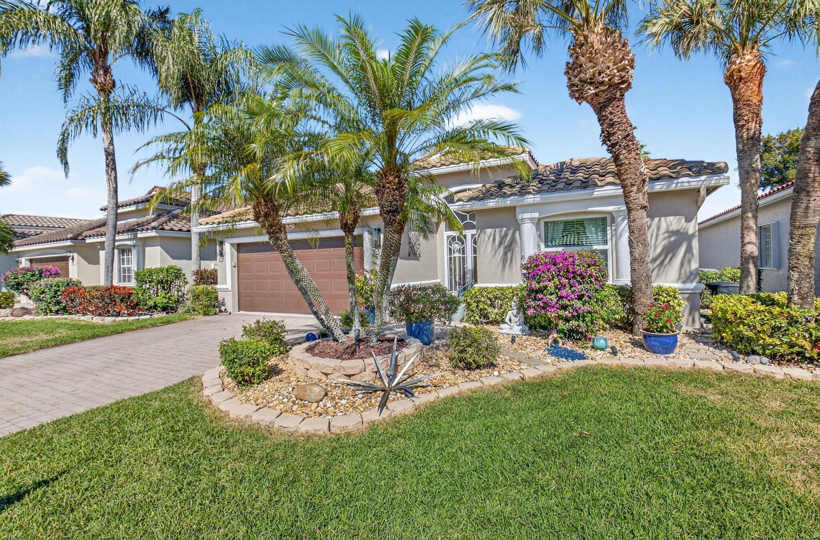 A single-story house with a brown garage, palm trees, and a landscaped front yard — 7051 Trentino Way, Boynton Beach FL 33472, BOYNTON BEACH, FL