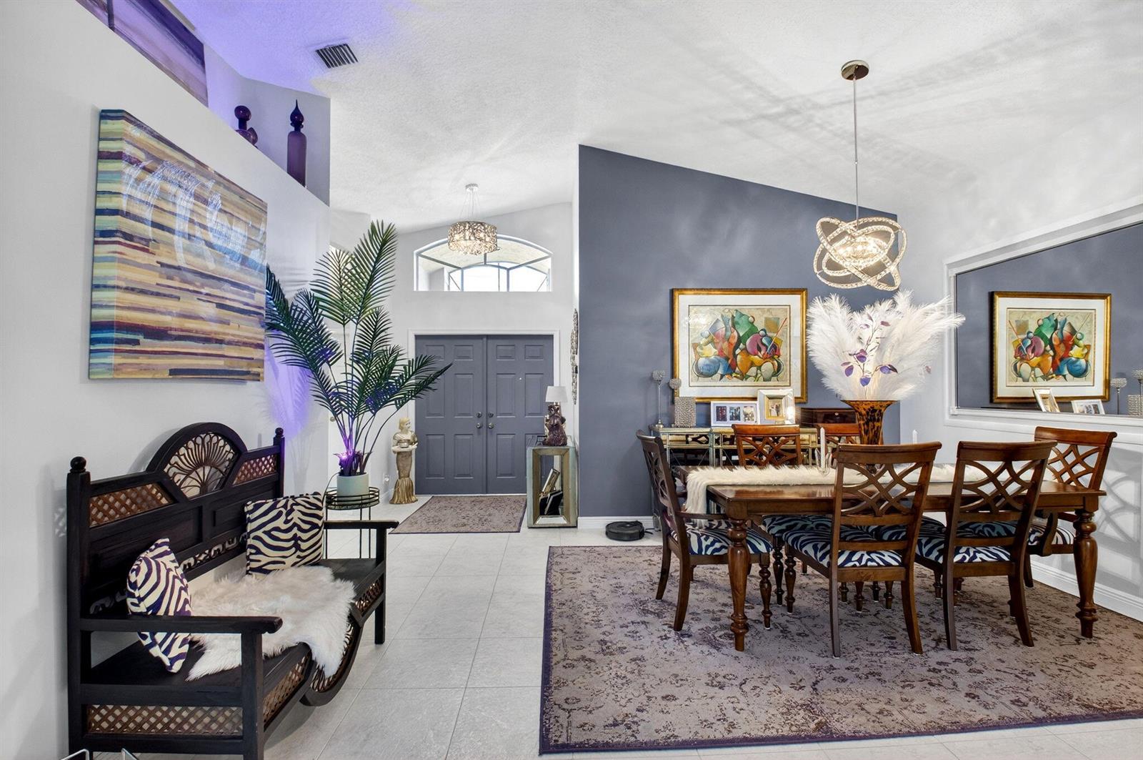 A dining area and entryway feature tile floors, a dark accent wall, and wooden furniture — 7051 Trentino Way, Boynton Beach FL 33472, BOYNTON BEACH, FL